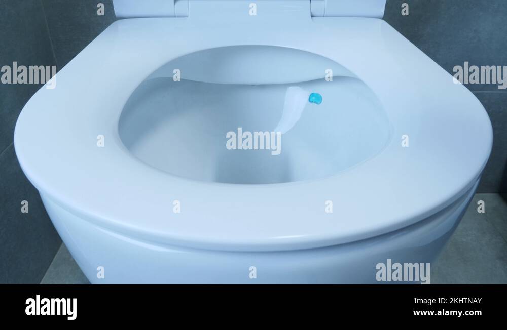 Closing toilet lid, close up view. Front view of white toilet with lid