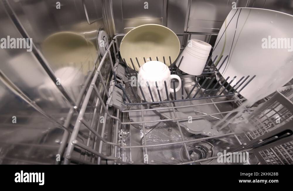 Washing Dishes in a Dishwasher Inside View. Water Splashing On Camera