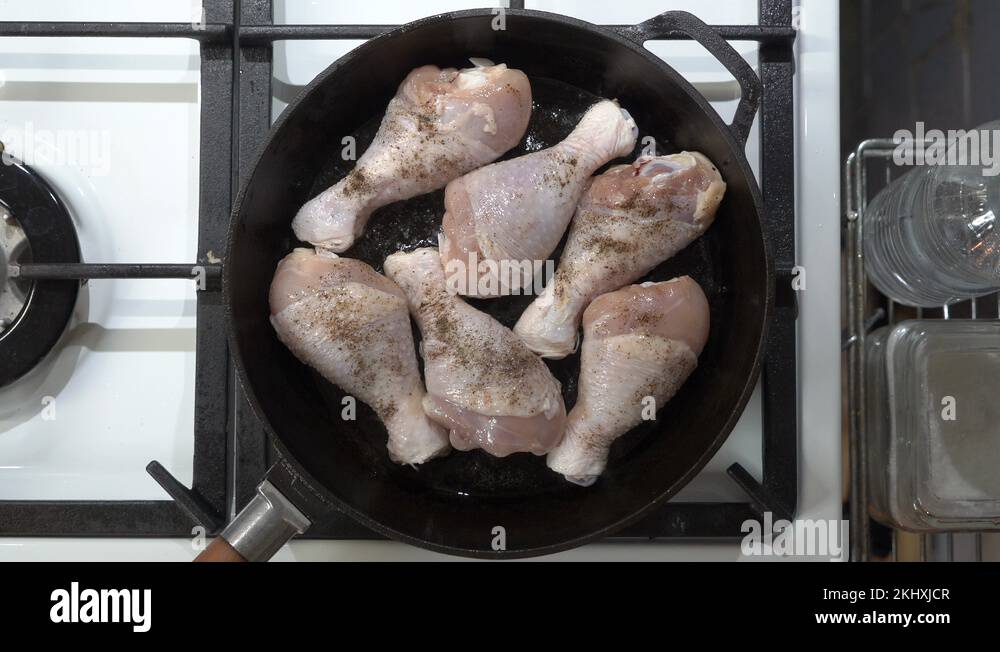 Making pan fried chicken drumsticks in cast iron frying skillet top