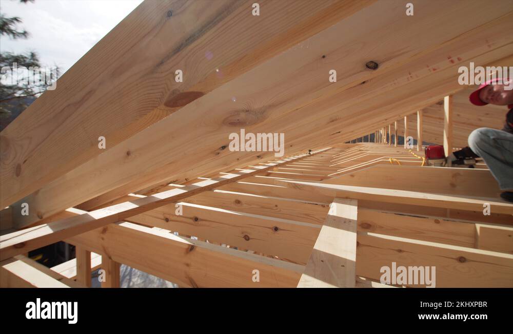 Team of builders nail plank with pneumatic nail guns. Frame house