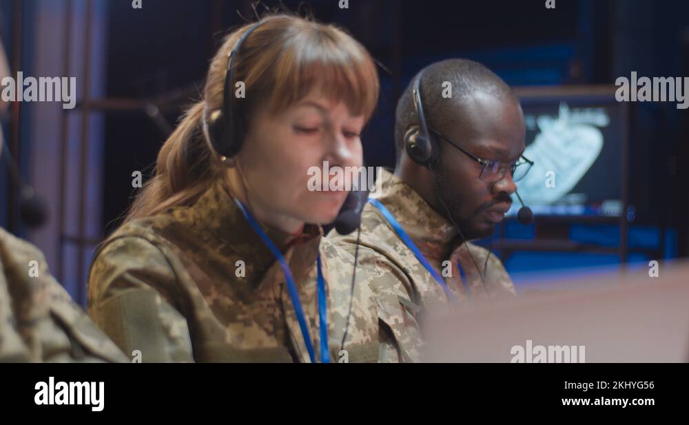 Multiethnic male and female military dispatchers in camouflage uniforms