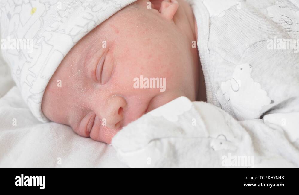 Closeup the face of a newborn baby in the early days who wakes up and