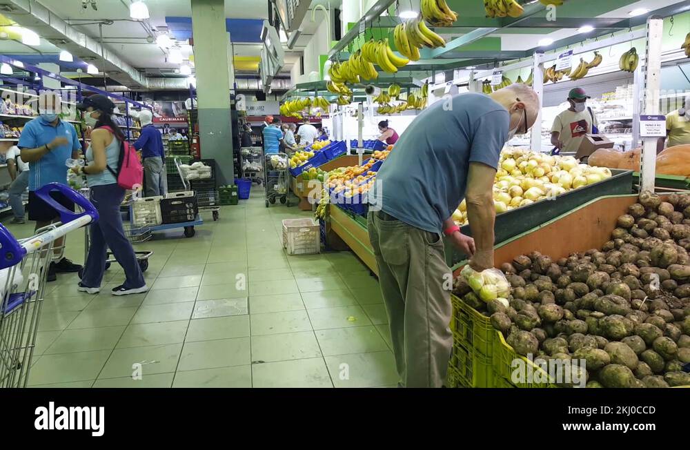 Some people grab vegetables from a supermarket shelves during the COVID