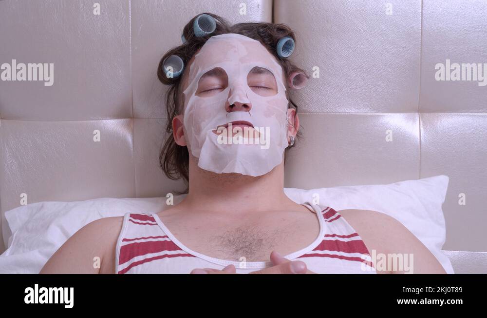 man with a cosmetic mask on his face in a room, opens his eyes sharply ...