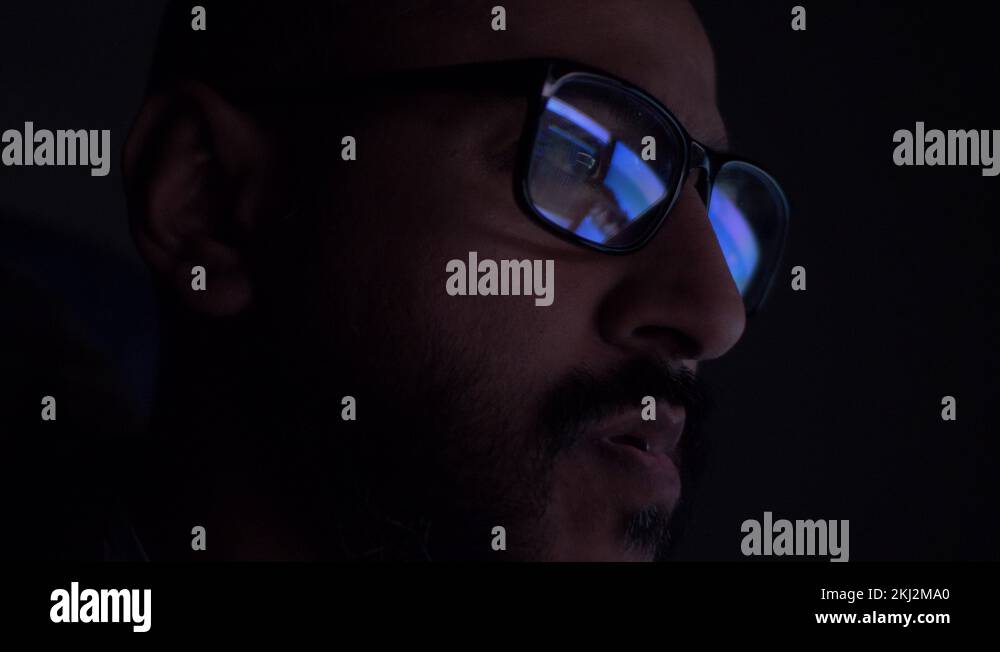 Asian Male Reading With Reflection Of Computer Screens Seen In Glasses