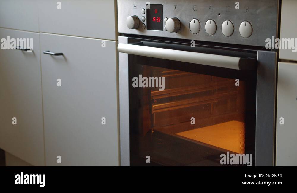 Putting raw bread and baked cheese into a oven by a women Stock Video Footage Alamy