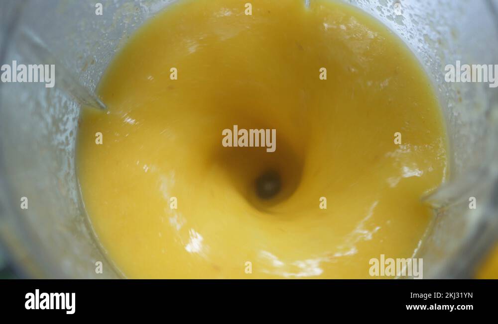 Making fresh mango fruit shake in blender. The concept of a healthy
