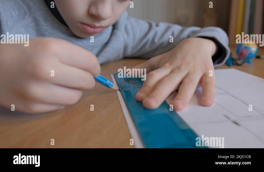 Schoolboy make homework and using drawing compass and ruler to draw a ...