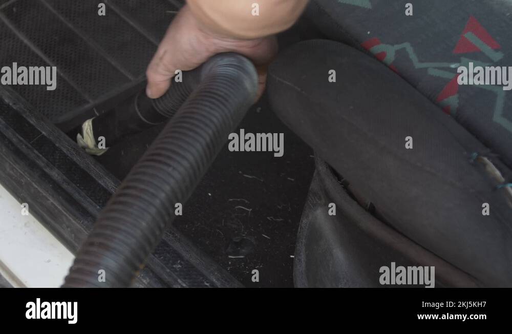 Man cleans, vacuums the car inside, old and dirty. Cleans the vehicle