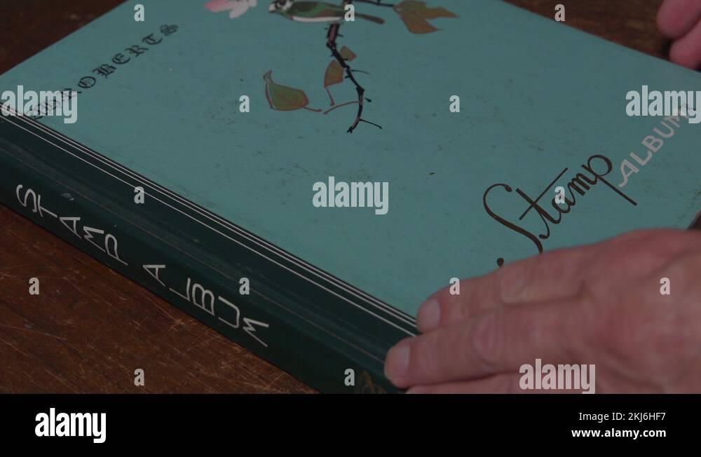 Opening by hand multiple pages of a stamp collectors album and closing
