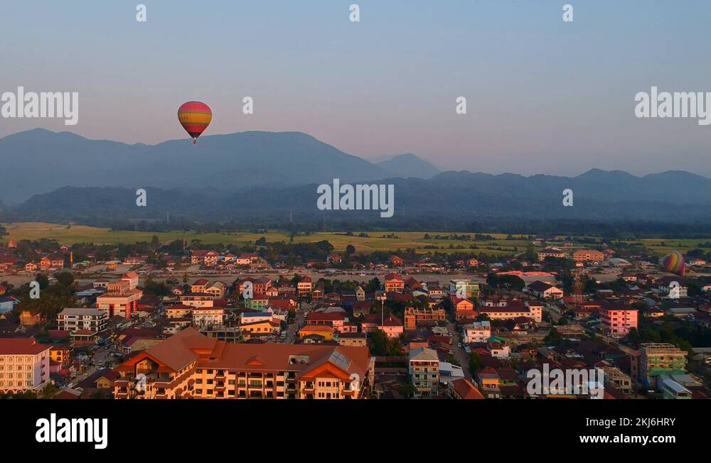 Colorful Hot Air Balloon Flying Over A Village In Laos On A Sunrise