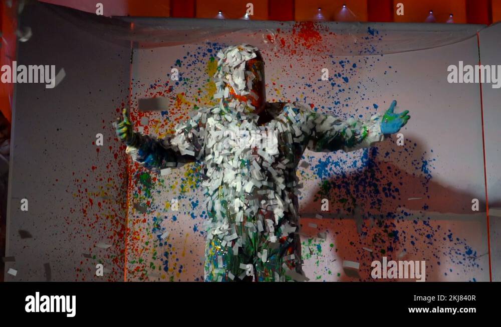 Paint and papers like Blue men group. A man in a white suit was sprayed