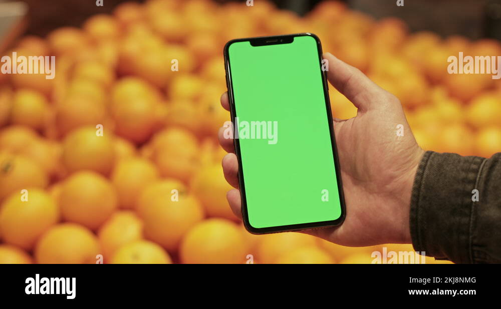 Close up view of hand holding modern mobilephone with template green ...