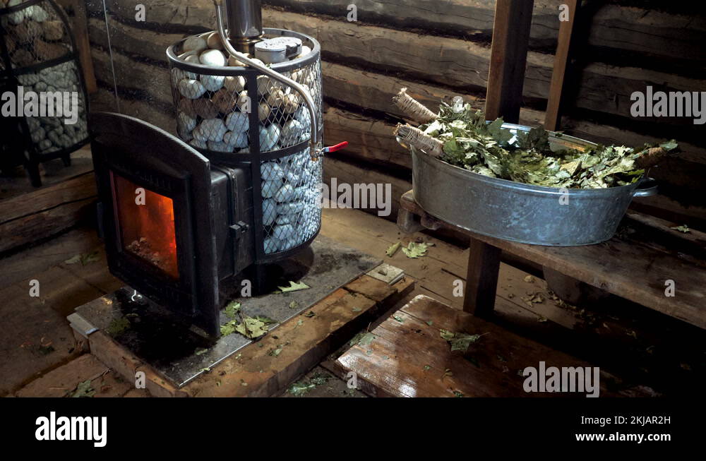 Russian steam bath. Closeup of woodburning stove, oak besoms in