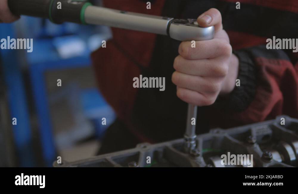 Male car mechanic with a specialized wrench, screw the nuts in the car engine Stock Video