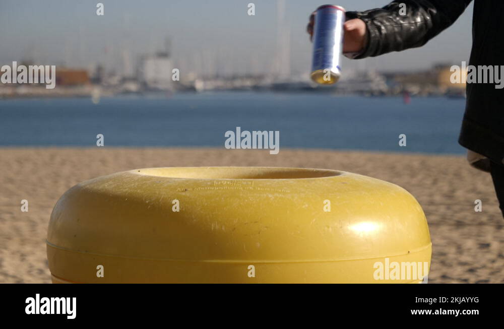 Lady throwing away can in garbage bin at the beach Stock Video Footage Alamy