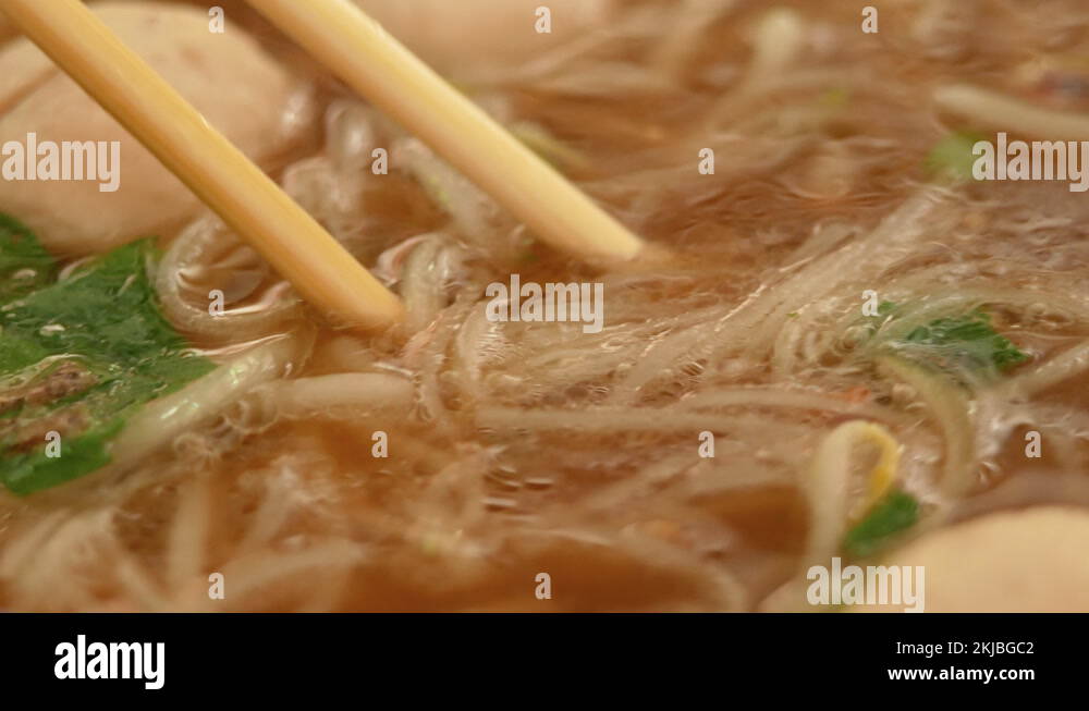 Hand use chopstick to pick noodles in a traditional Vietnamese beef