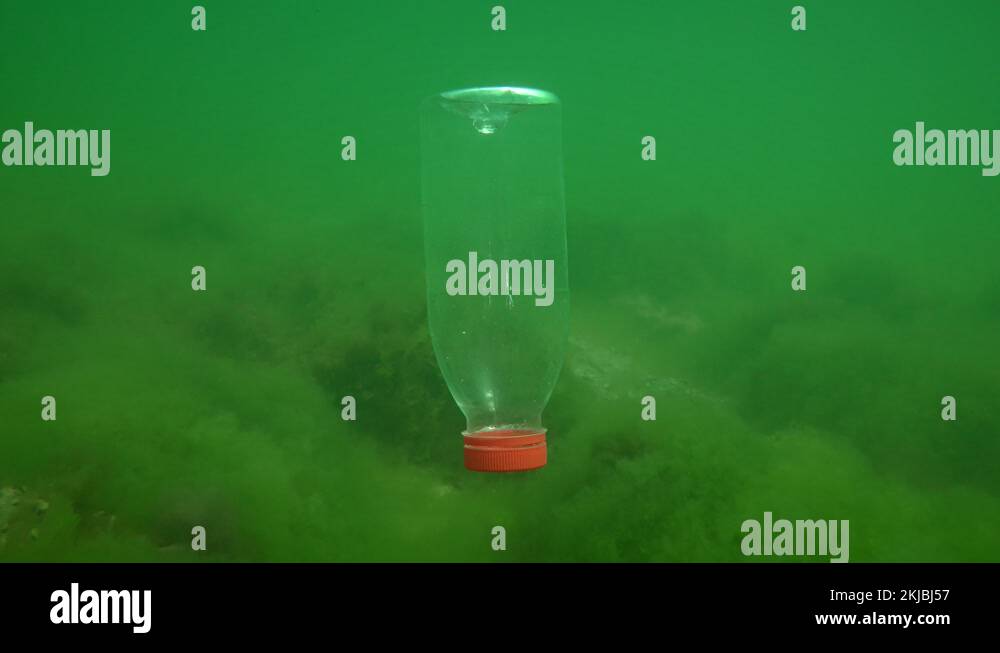 Plastic pollution of the sea PVC bottle slowly sinks to the bottom