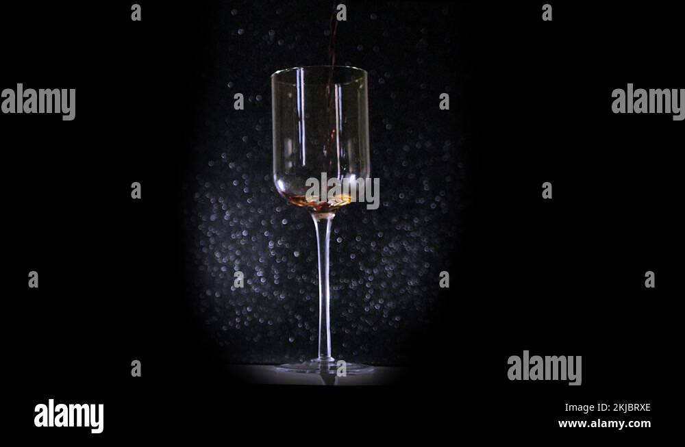 Wine pour slow motion glitter background. Super slomo shot of red wine