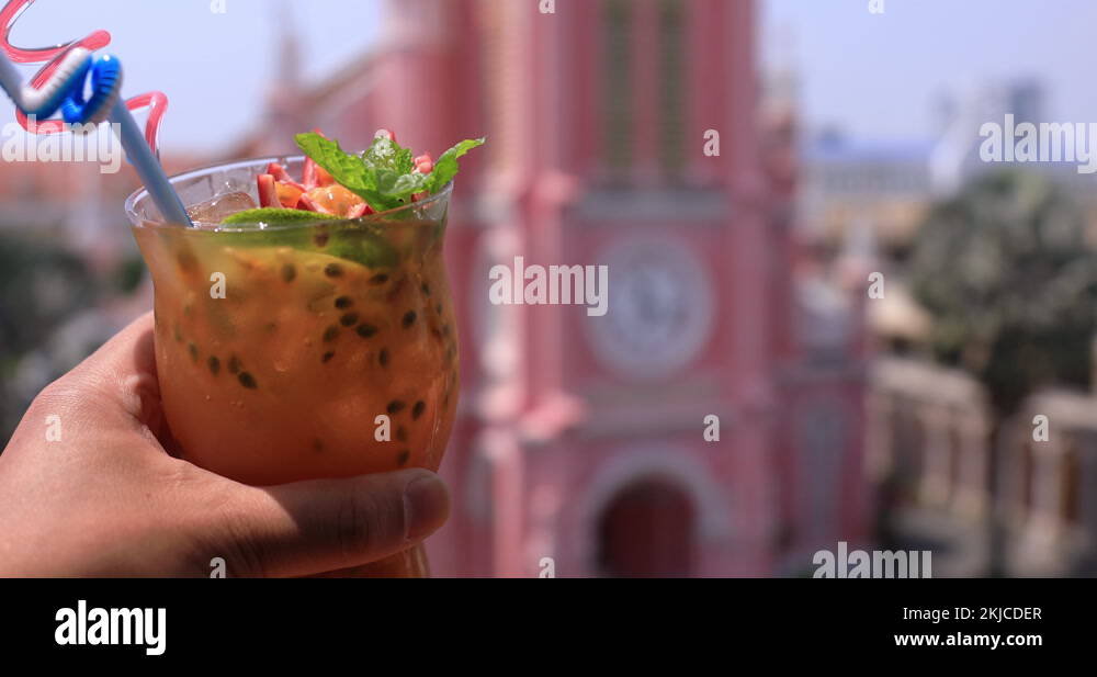 Tropical juice with hand behind Tan Dinh church in Ho Chi Minh focusing