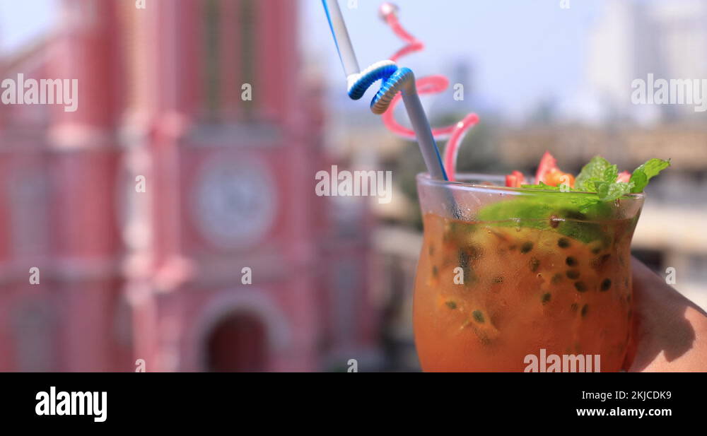 Tropical juice with hand behind Tan Dinh church in Ho Chi Minh handheld