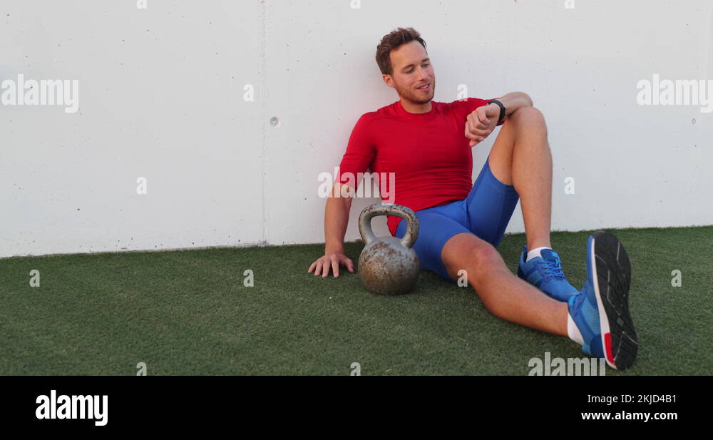 Fitness gym training man looking at fitness activity tracker with