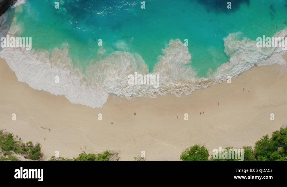 Drone footage of white sand beach with azure water, foaming ocean waves ...