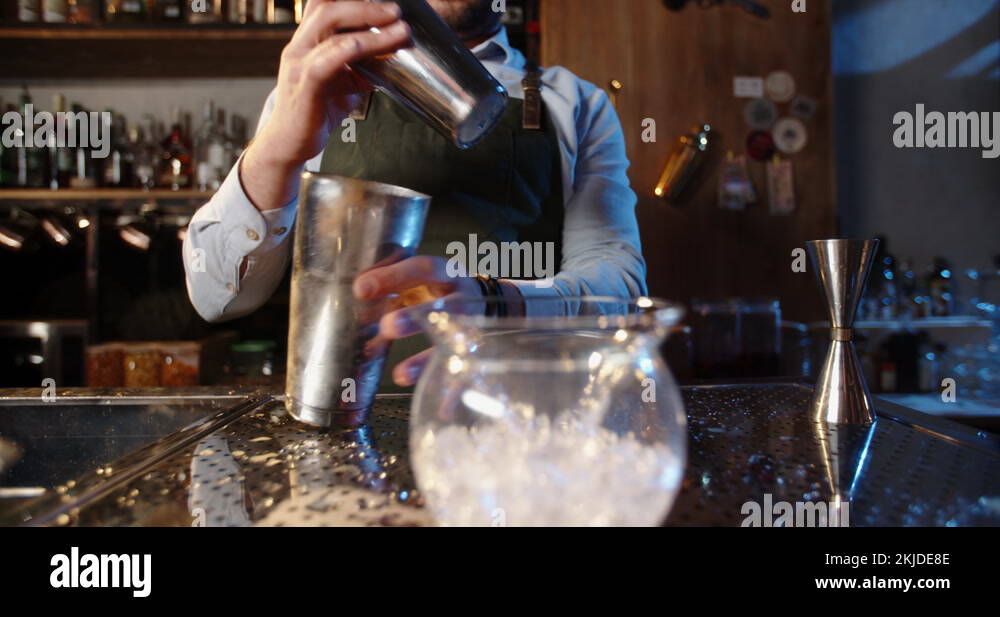 Authentic professional bartender flaring his shaker before making a