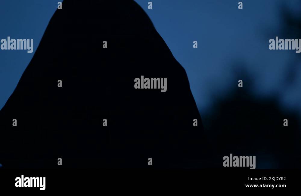 Mysterious Cloaked Figure With Flashing Evil Eyes In Dark Halloween