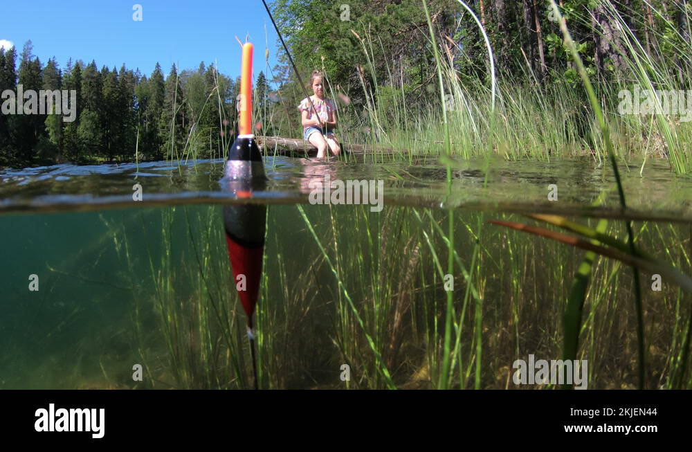 Little girl fishing with underwater view of fishing float and weed on a