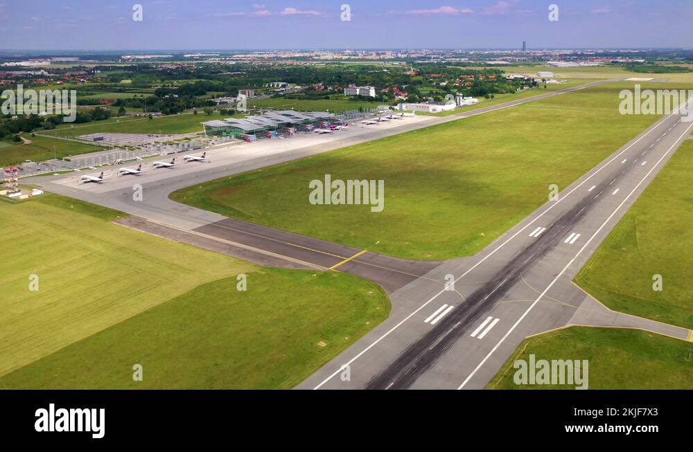 Airport terminal, airport apron and runway at 11 approach seen from