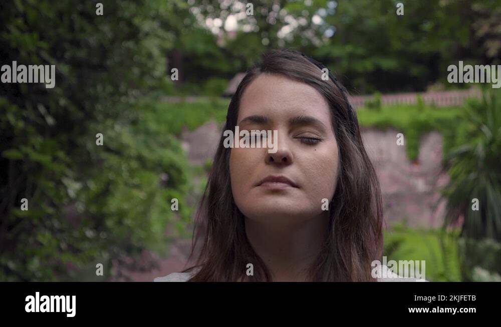 Woman face opening eyes in meditation looking up to the sky with hope ...