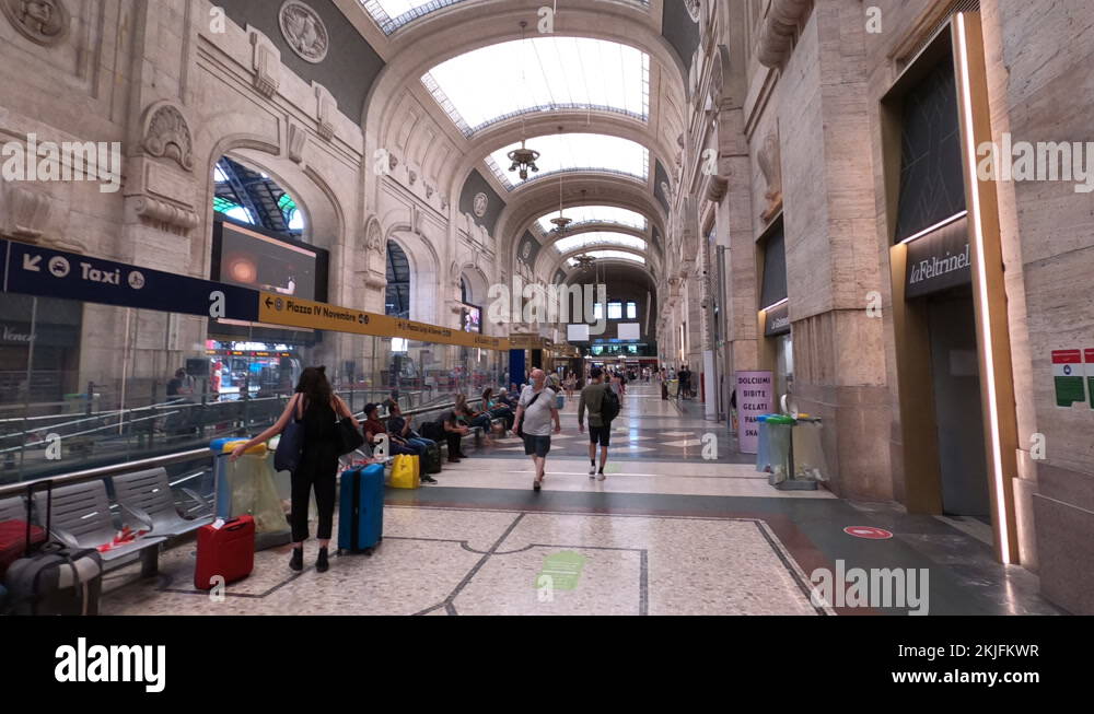 Walking through train station in Milan, people wear face masks in Italy