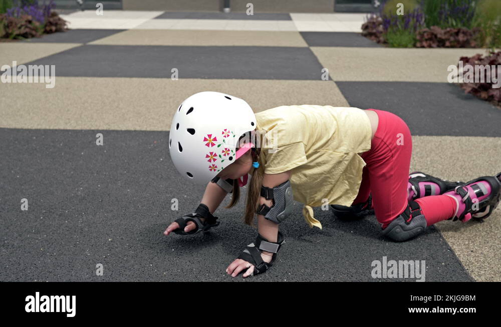 Little girl falling while roller skating. She can hardly get to her