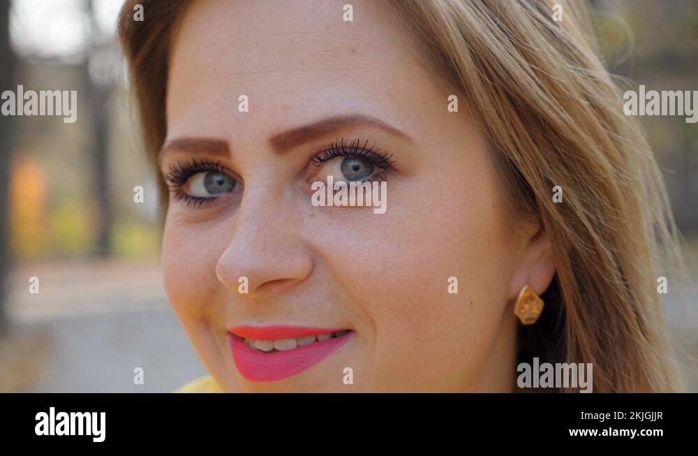 Close up female head face eyes nose lips. Girl pink lipstick smiles