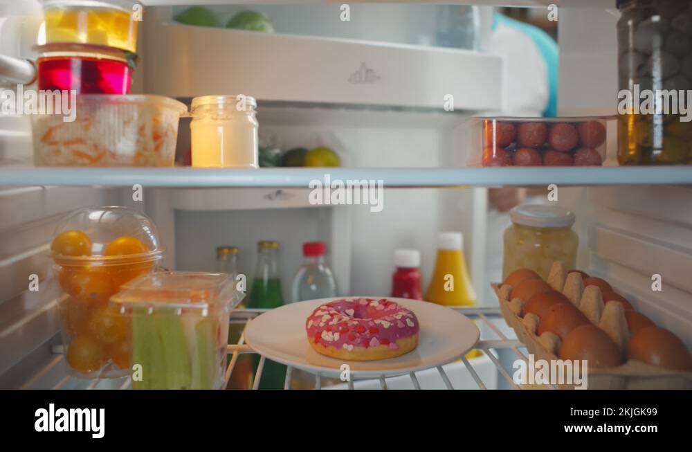 Fat man opening fridge and choosing donut for snack Stock Video Footage