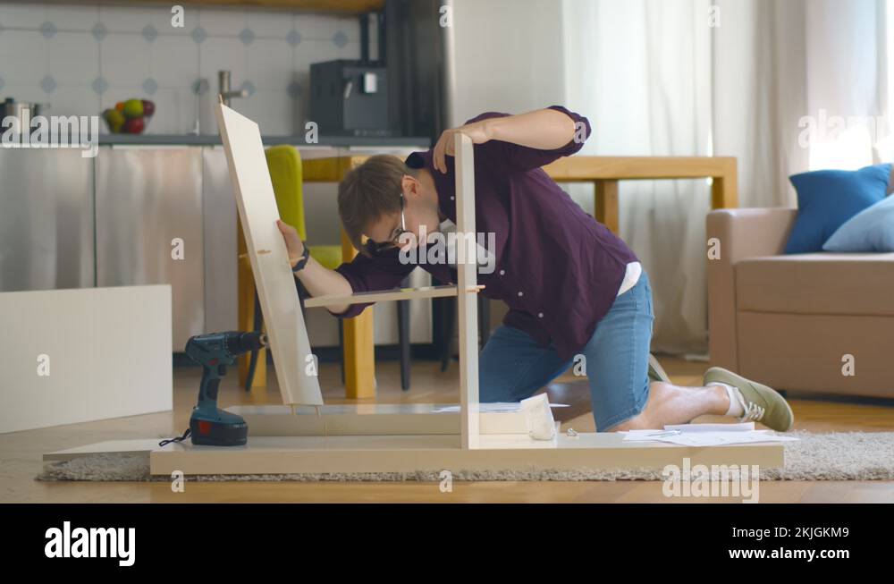 Man Putting Together Self Assembly Furniture In New Home Stock Video