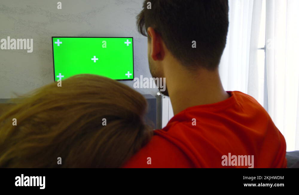 Couple in living room with green screen tv. Girl hugging boy Stock ...