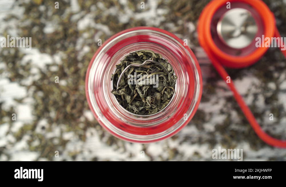 teaspoon adds dried green tea leaves to the teapot Stock Video Footage