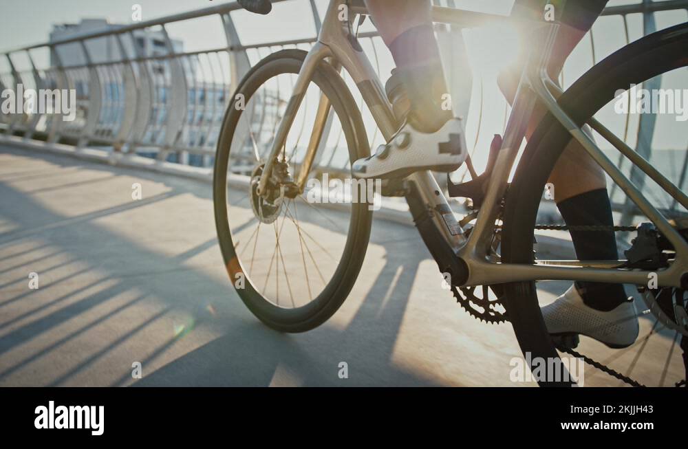 Legs of girl professional cyclist in cycling shoes who riding a bike