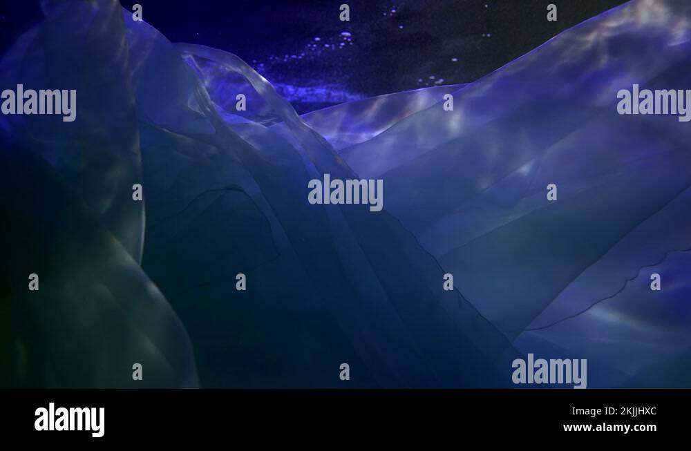 white silk fabric is floating in dark deepness of sea or ocean