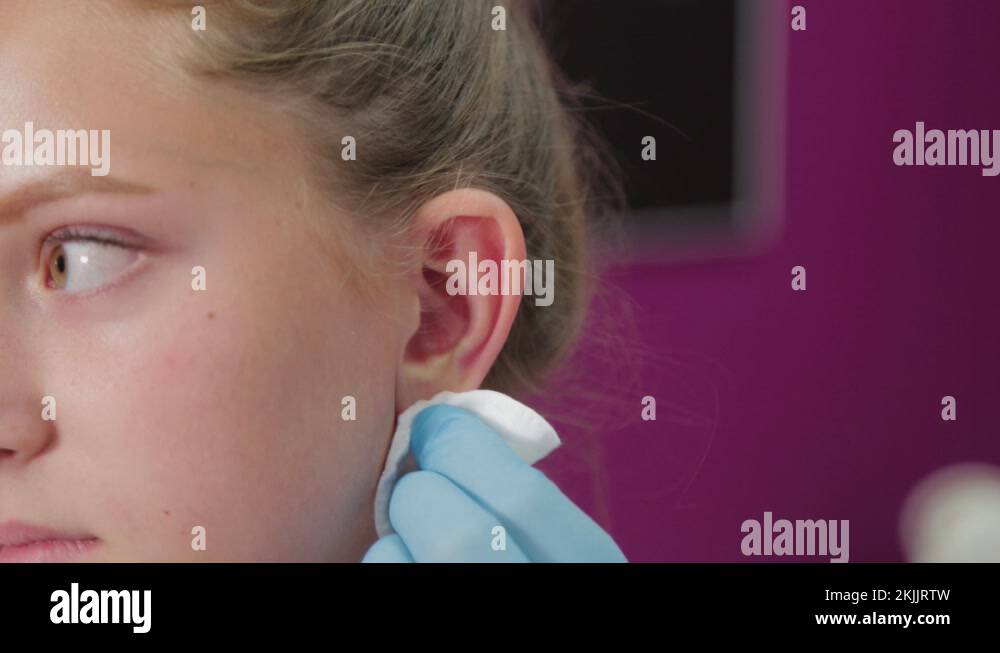 Woman doctor conducts ear piercing procedure for girl Stock Video Footage Alamy