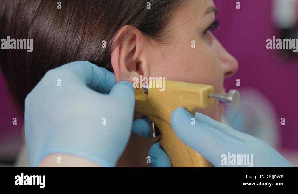 Doctor woman conducts ear piercing procedure for client Stock Video