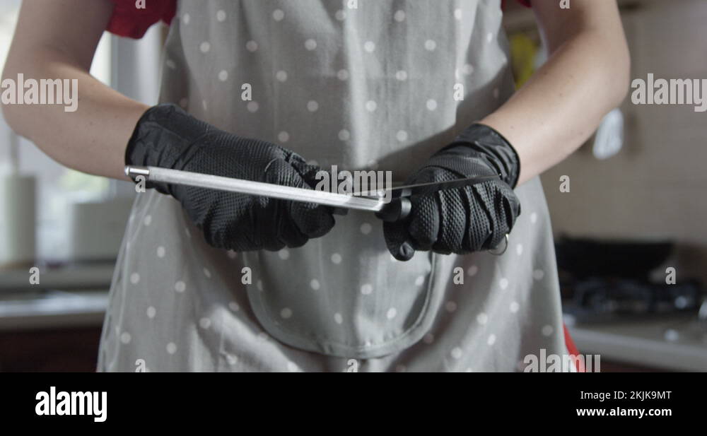 Woman Chef is Sharpening Knife with a Steel Rod Sharpener in the
