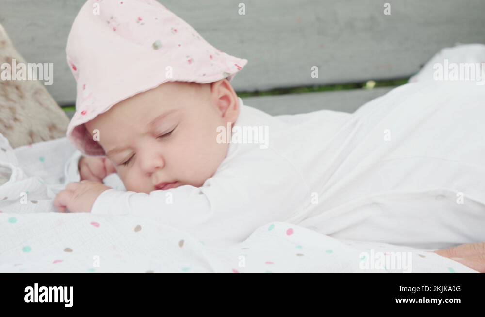 newborn baby girl five months of age lying on tummy on swing bench