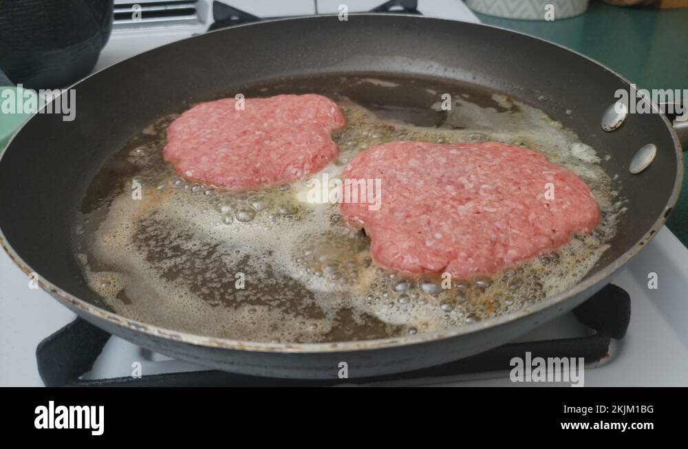 Frying two lamb burgers over butter in non stick skillet or pan using