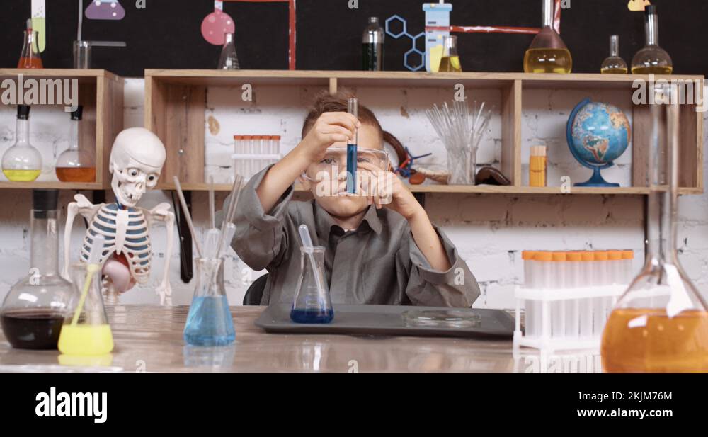 Laboratory experience in a chemistry lesson, the boy looks at the flask