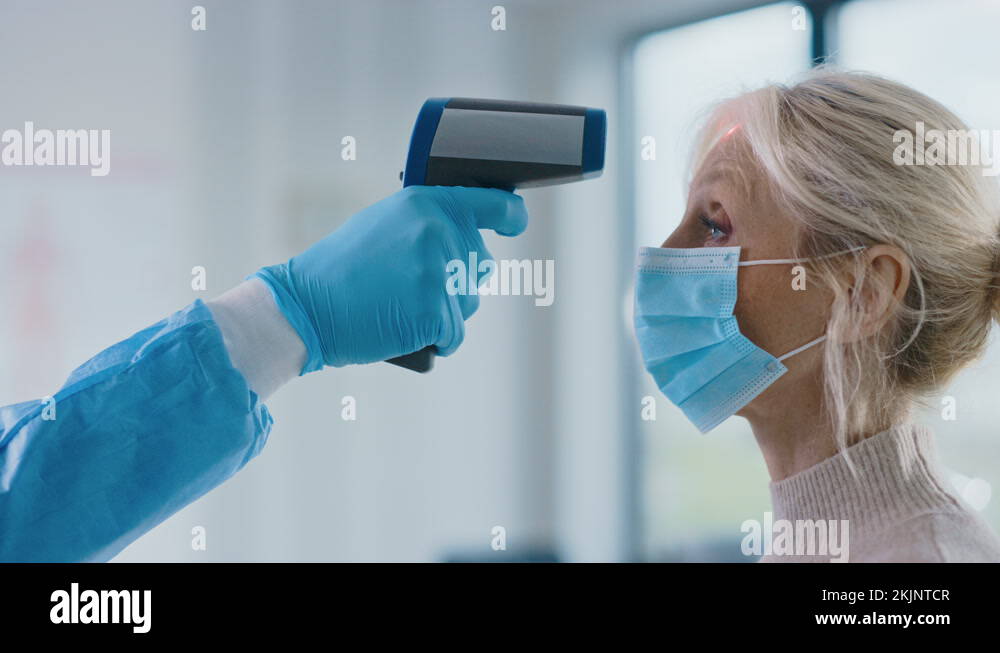 Medical Doctor Measuring Body Temperature with Infrared Thermometer