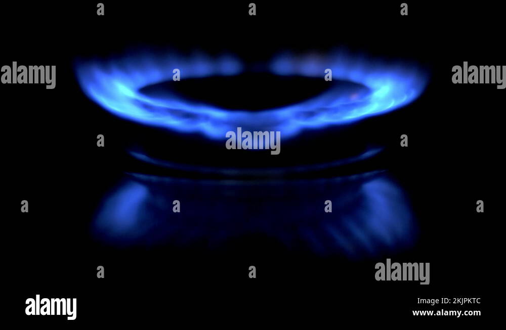 Gas is switching on, apearing blue flame. Gas stove on black background