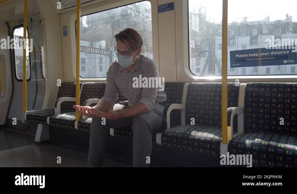 A man wears a mandatory surgical face mask to ride an underground train